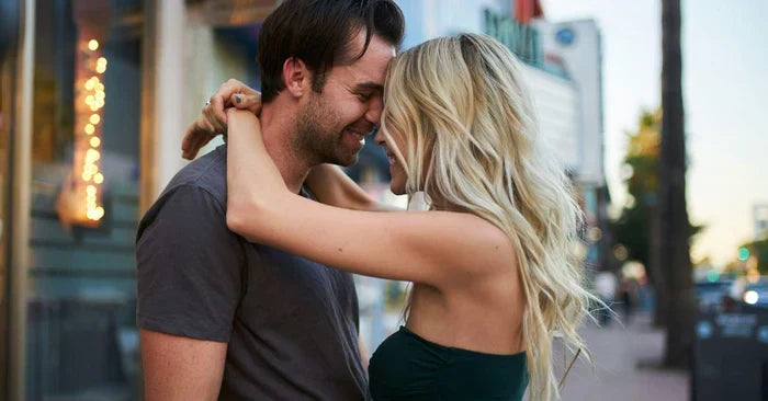 Girl wrapping her arms around the guy's neck